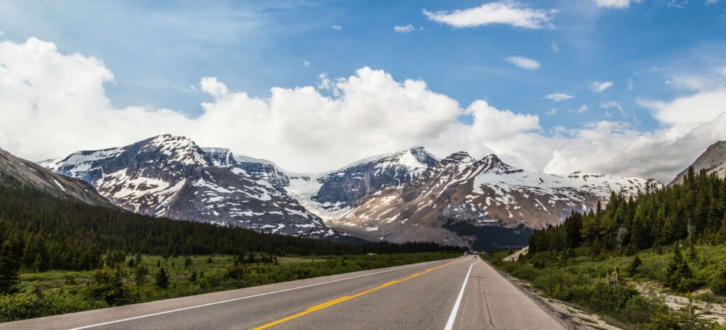 Road in Alberta, mountains in the distance.