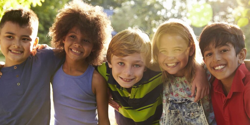 Portrait Of Five Children Having Fun Outdoors Together